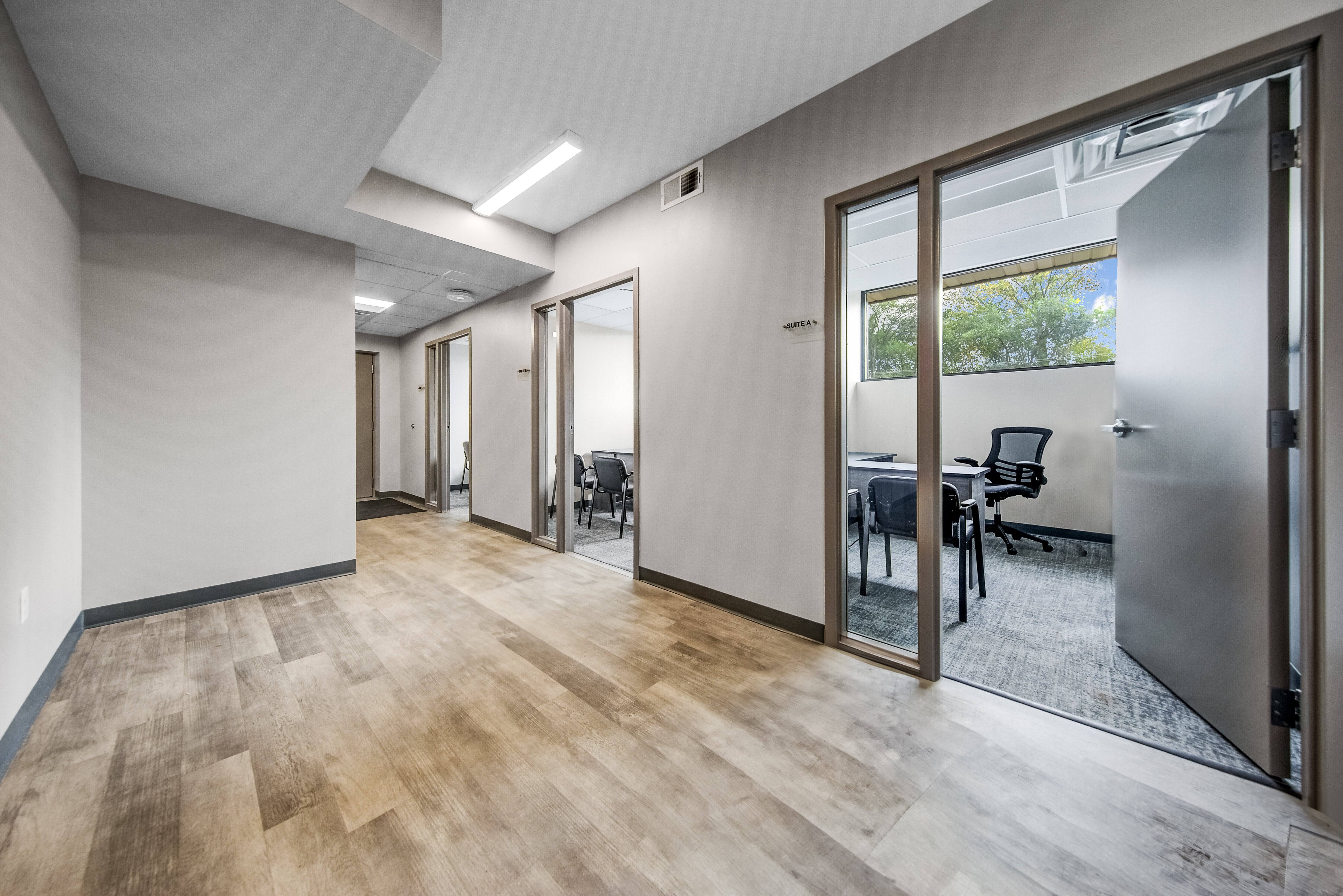 Hallway of private rental offices at Storage on 7th in Faribault, Minnesota, with a furnished suite visible, natural light, and modern finishes.
